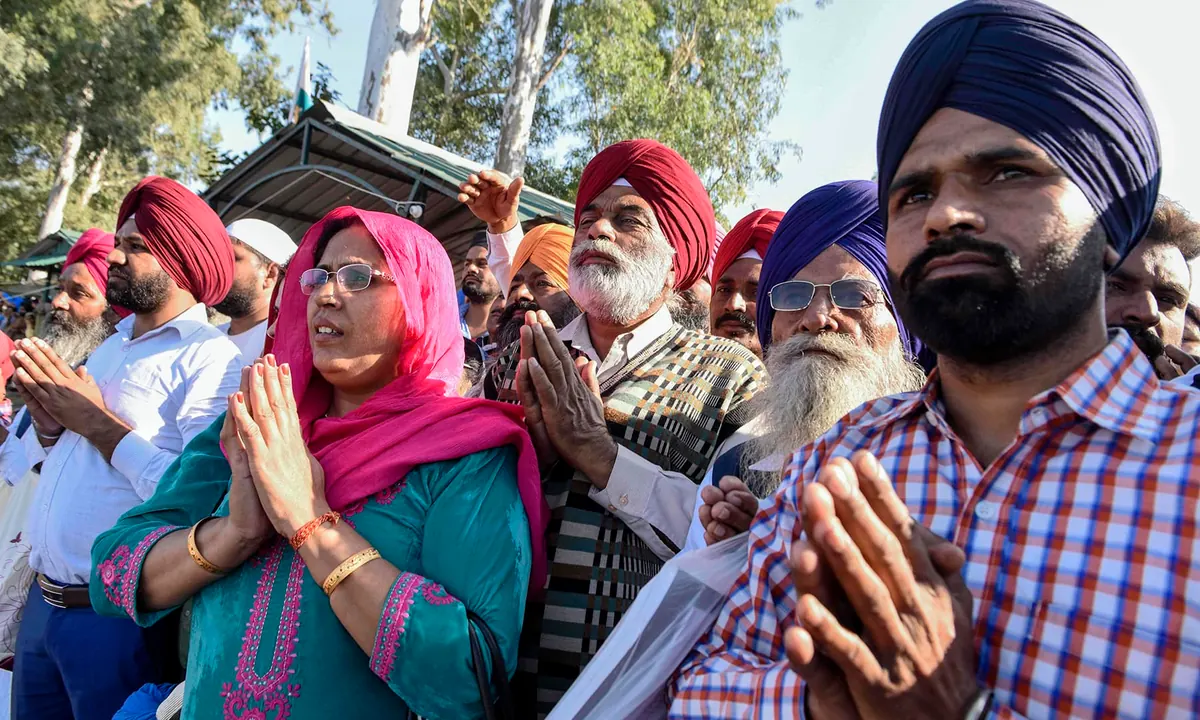 Sikh devotees offer prayers towards the shrine of Guru Nanak Dev Ji at Gurdwara Darbar Sahib.